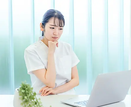 パソコンの前で悩む女性